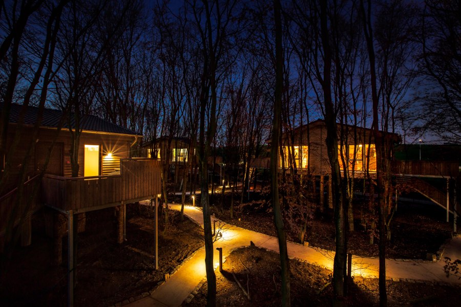Baumchalets Außenansicht bei Nacht, © @ Hotel Fire & Ice im Alpenpark Neuss